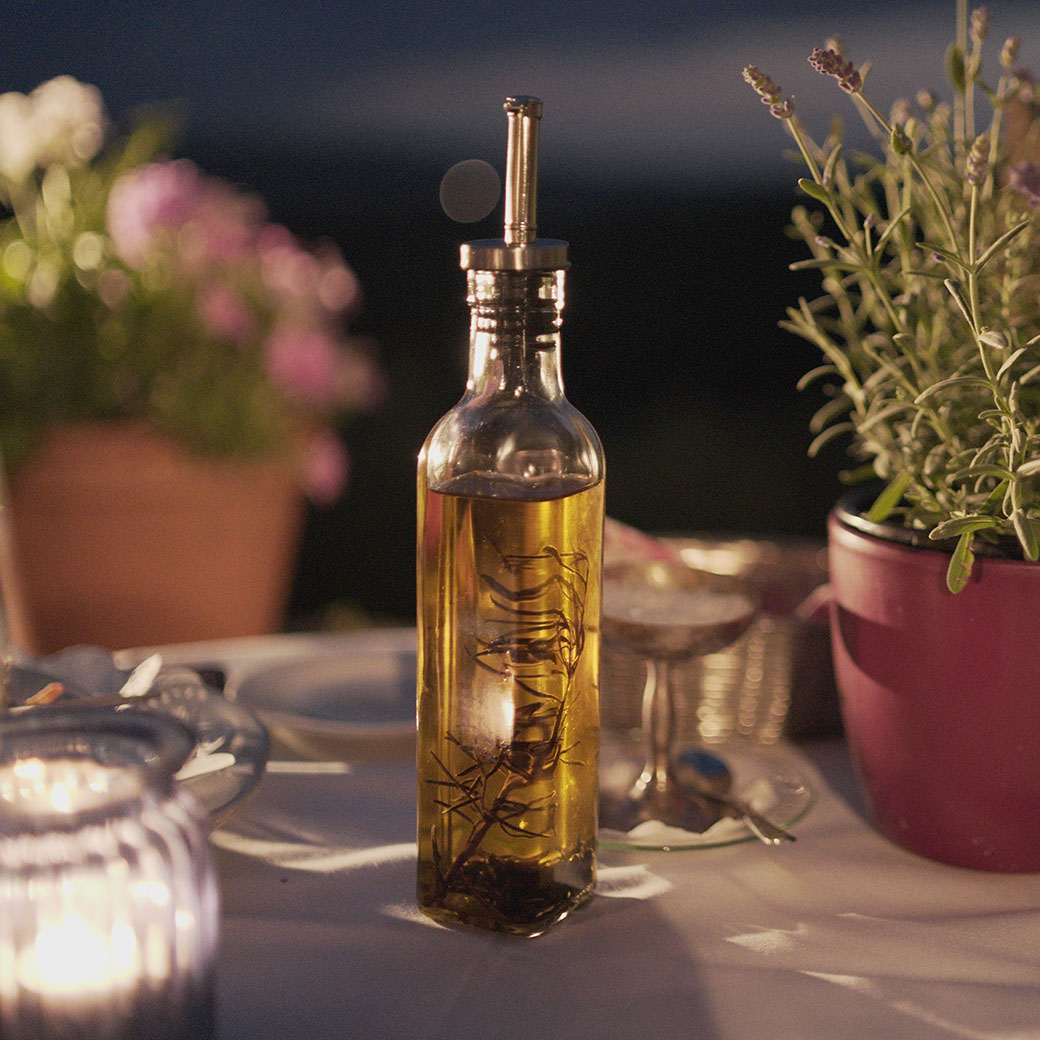 Bottle of olive oil sitting on a dinner setting
