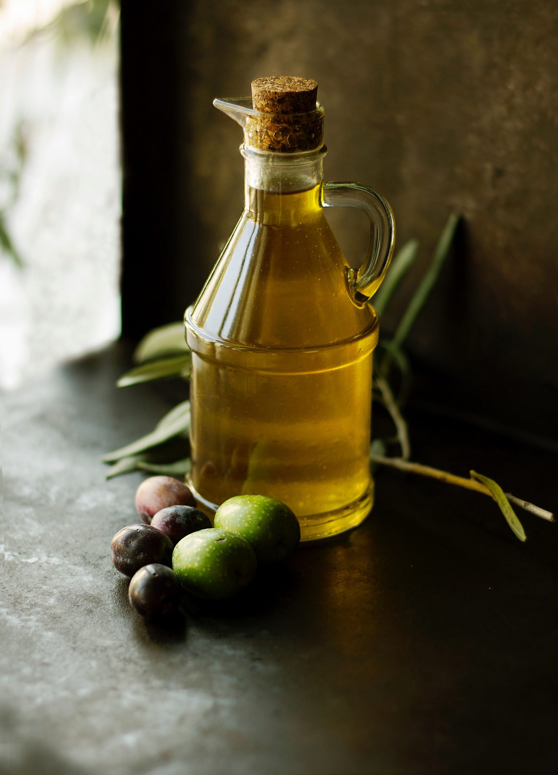 Bottle of olive oil and olives on a table